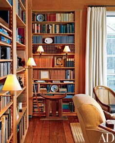 a living room filled with lots of books and furniture