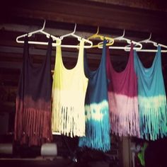 four different colored dresses hanging on a rack