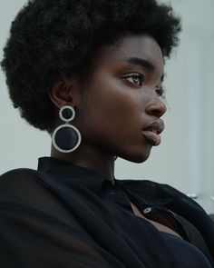 a woman with an afro is wearing earrings