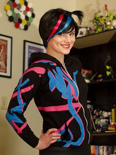 a woman with black hair wearing a colorful outfit