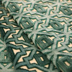 a close up view of a green and white pattern on a fabric with an interesting design