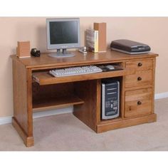 a wooden desk with a computer on top of it and a keyboard in the middle