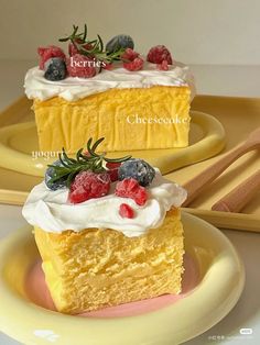 two pieces of cake on yellow plates with strawberries and raspberry toppings