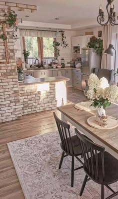 a dining room table with chairs and flowers in vases on top of the table