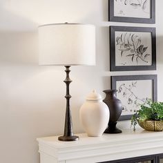 two vases and a lamp are sitting on a mantle