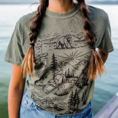 Our newest design for spring! We are so ready to explore the national forests this summer!! Unisex tee - model is wearing a medium Body Length 28 29 30 31 32 Chest Width (Laid Flat) 18 20 22 24 26 A Montana Scene Original Design. Printed in Montana. All designs are property of The Montana Scene. All rights reserved. All of The Montana Scene apparel is designed and printed locally in Montana. Come visit our storefront locations! Bigfork * Whitefish * Missoula * Kalispell * Bozeman Casual Relaxed Fit T-shirt For Outdoor Activities, Summer Short Sleeve T-shirt For Outdoor Activities, Spring Outdoor Cotton Camp Shirt, Casual T-shirt For Outdoor Summer Activities, Green Short Sleeve Tops For Outdoor, Casual Summer T-shirt For Outdoor, Short Sleeve Tops For Outdoor Spring Activities, Short Sleeve Tops For Spring Outdoors, Short Sleeve Tops For Spring Outdoor Activities