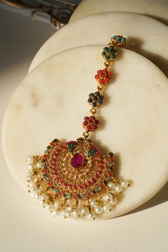 Introducing the Imaari Statement Necklace Set with Maang Tikka and Chandbali Earrings. This exquisite necklace set features multicolor navratan stones with elegant gold plating and high-quality brass filling. The set includes a stunning maang tikka and matching chandbali earrings, making it a perfect style statement for special occasions or parties. The Imaari necklace set is designed to blend tradition with elegance. The intricate design of the maang tikka and the dazzling chandbali earrings co Festive Multicolor 22k Gold Bridal Necklace, Festive Multi-stone Gold Jewelry Sets, Festive Gold Multi-stone Jewelry Sets, Multicolor Jewelry Sets With Intricate Design For Celebration, Festival 22k Gold Multi-stone Jewelry, Festive Gold Multi-stone Jewelry, Traditional Gold Plated Multi-stone Jewelry, Traditional Multi-stone Gold Plated Jewelry, Celebration Temple Jewelry Tikka With Hand Set