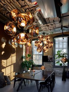 a room with many lights hanging from the ceiling and tables in front of it,