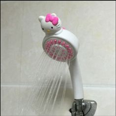 a hello kitty shower head is shown in the shower with pink and white hair on it