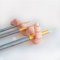 three pencils with faces drawn on them sitting next to each other in the shape of fingers