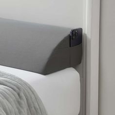 a close up of a bed with a gray headboard