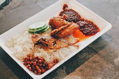 a white plate topped with rice and meat