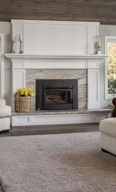 a living room with white furniture and a fireplace