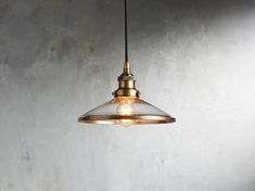 a light hanging from a ceiling in a room with concrete walls and flooring on the side