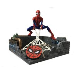 a spider - man statue sitting on top of a brick wall