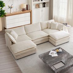 a living room with a large sectional couch and coffee table in it's center