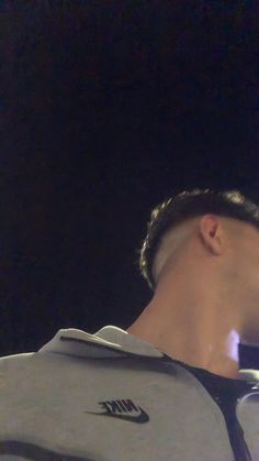 a close up of a person wearing a nike shirt and holding a cell phone to his ear