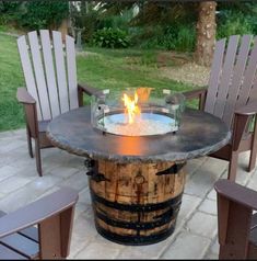 an outdoor fire pit with chairs around it