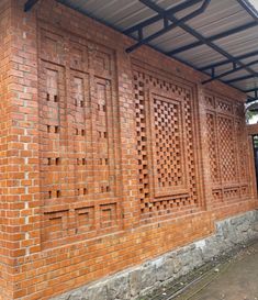 a red brick building with a metal roof and windows on the side of it that is made out of bricks