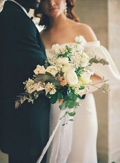 the bride and groom are standing close together