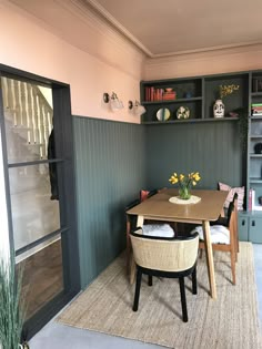 a table and chairs in a room with green walls