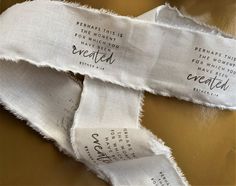 two pieces of torn white fabric with words on them