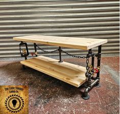 a wooden bench sitting on top of a metal pipe and wood table with chains hanging from it