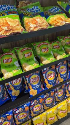 chips and potato chips are on display in a grocery store, along with other snacks