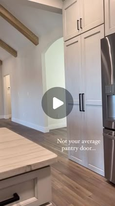 an empty kitchen with stainless steel appliances and wood flooring, not your average pantry door