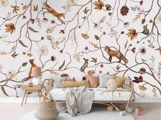 a living room with a couch and wallpaper that has birds on the tree branches