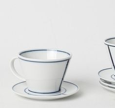 two cups and saucers sitting next to each other