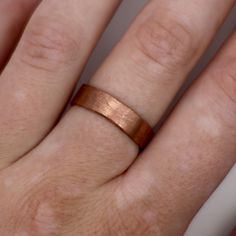 a close up of a person's hand with a wedding ring on their finger