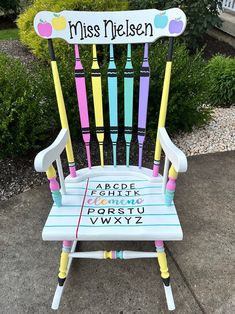 a colorful wooden chair with writing on it