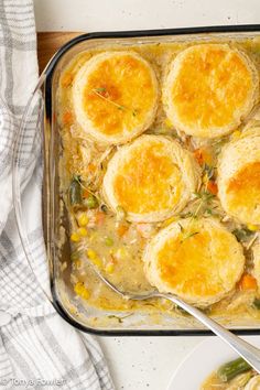 a casserole dish filled with biscuits and vegetables