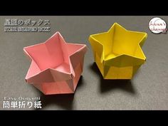 two origami bowls sitting next to each other on top of a gray table