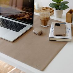 an open laptop computer sitting on top of a desk next to a cup of coffee