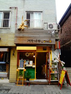 a store front with various items on display in the window and outside, along with stairs leading up to it