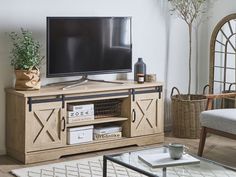 a living room scene with the television on and an entertainment center in front of it