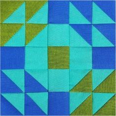 a blue and green piece of fabric with squares on it that have been cut into triangles