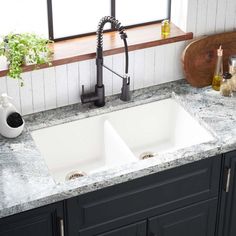 a white kitchen sink sitting under a window