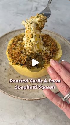 a person is holding a fork in a stuffed garlic and parm spaghetti squash dish