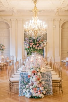 a long table with flowers and candles is set up in the middle of a room