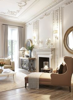 a living room filled with furniture and a fire place in front of a mirror on the wall