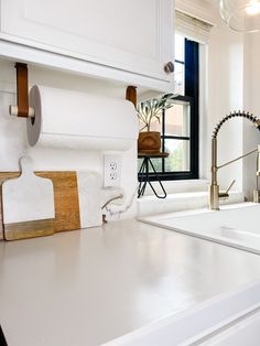 a kitchen with white counter tops and wooden handles on the faucet above the sink