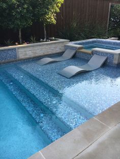 an empty swimming pool with lounge chairs on the side and steps leading up to it