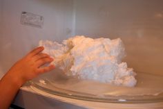 a hand is reaching into an open refrigerator door to grab something out of the freezer