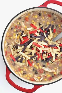 a red pot filled with corn, black beans and cheese