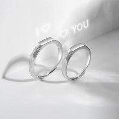 two silver rings with i love you written on the front and back, sitting next to each other