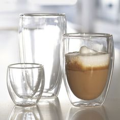 three glasses filled with liquid sitting on top of a table next to each other,