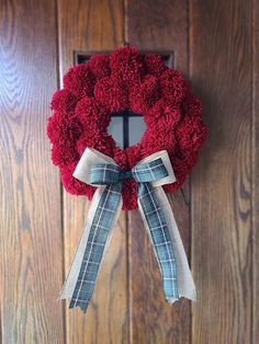 a red wreath hanging on the front door